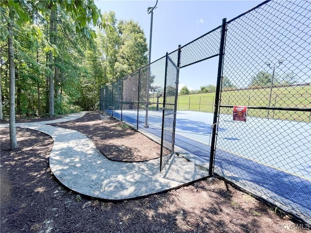 view of basketball court with fence