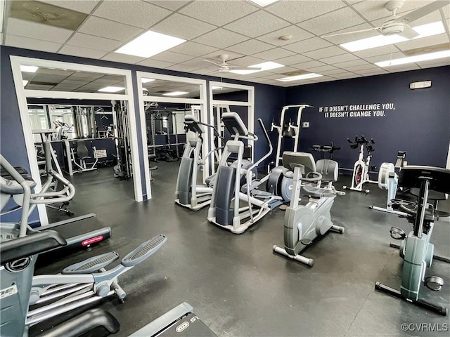 gym with a ceiling fan and a drop ceiling