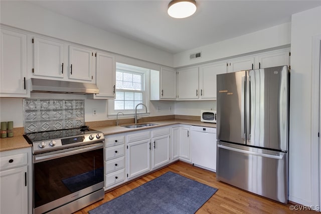 kitchen with visible vents, a sink, light countertops, under cabinet range hood, and stainless steel appliances