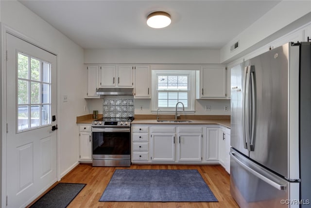 kitchen featuring visible vents, stainless steel appliances, a sink, under cabinet range hood, and a wealth of natural light