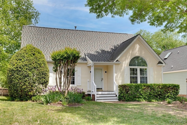 view of front facade featuring roof with shingles and a front lawn