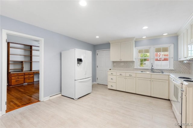 kitchen featuring tasteful backsplash, light wood-style flooring, a sink, light countertops, and white appliances
