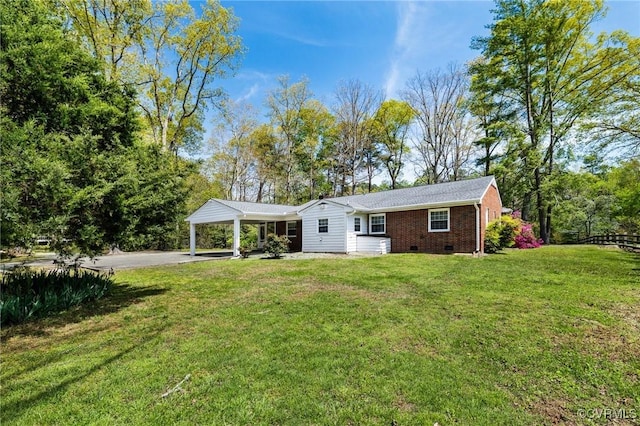 view of front of home featuring brick siding, a front yard, driveway, and crawl space