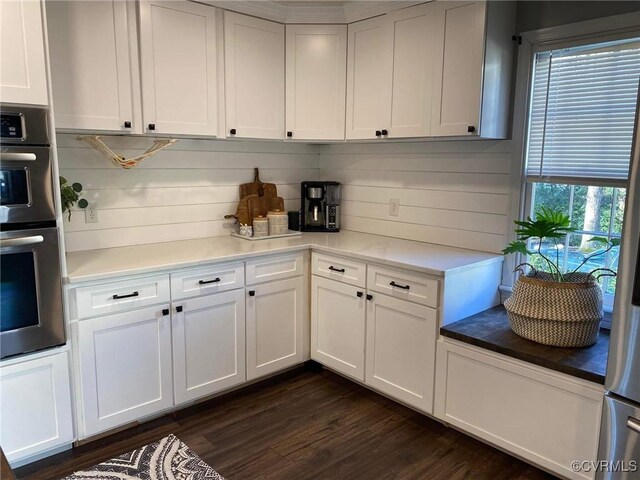 kitchen with white cabinets, dark wood-style flooring, and double oven