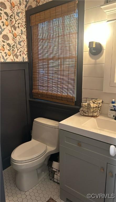 bathroom with vanity, tile patterned floors, toilet, and wallpapered walls
