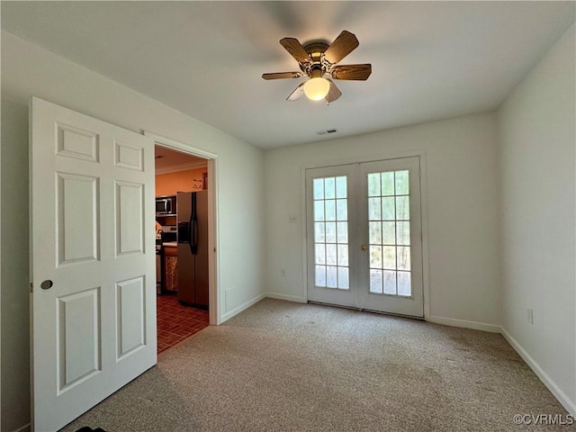 spare room featuring visible vents, baseboards, ceiling fan, french doors, and carpet flooring