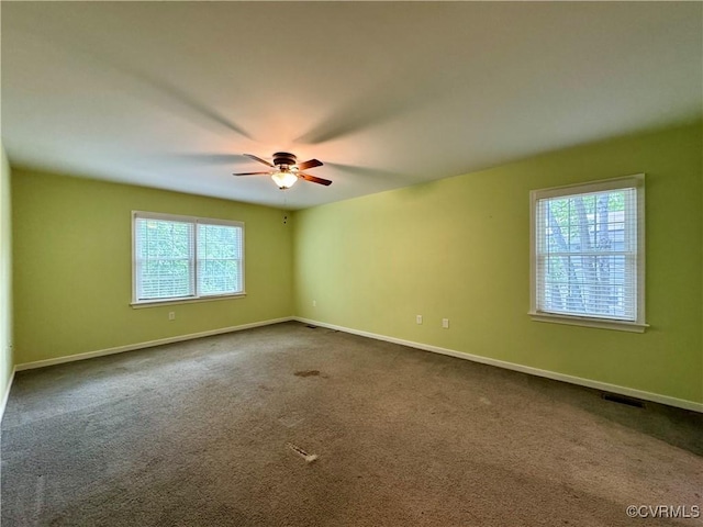 unfurnished room featuring dark colored carpet, baseboards, and ceiling fan