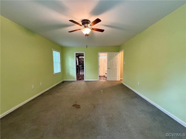 carpeted spare room featuring baseboards and ceiling fan