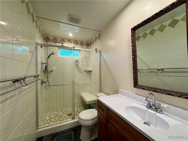 full bathroom featuring vanity, toilet, and a shower stall