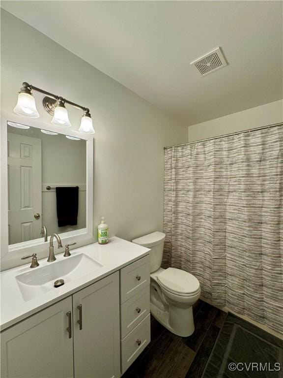 full bathroom with visible vents, wood finished floors, vanity, toilet, and a shower with shower curtain
