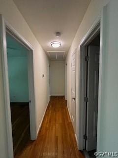 corridor featuring attic access and wood finished floors