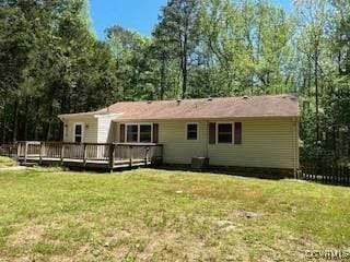 rear view of property with a deck and a yard