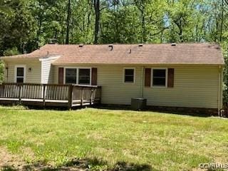 rear view of property featuring a wooden deck and a yard