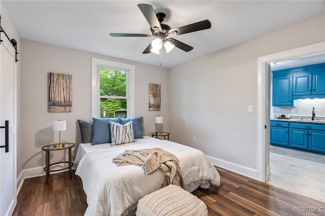 21300 W St, South Chesterfield, VA 23803 - bedroom featuring a sink, a barn door, ensuite bath, baseboards, and wood finished floors
