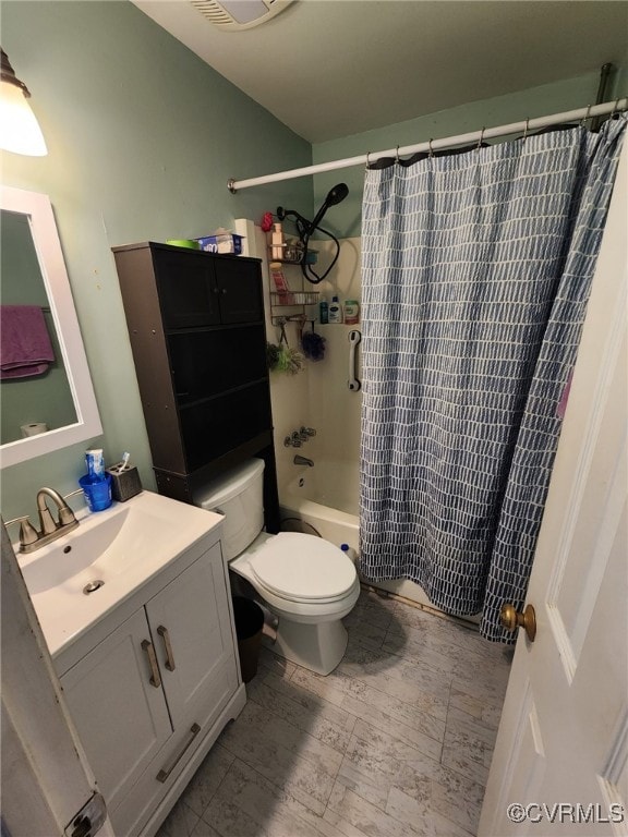 bathroom with vanity, shower / tub combo with curtain, and toilet