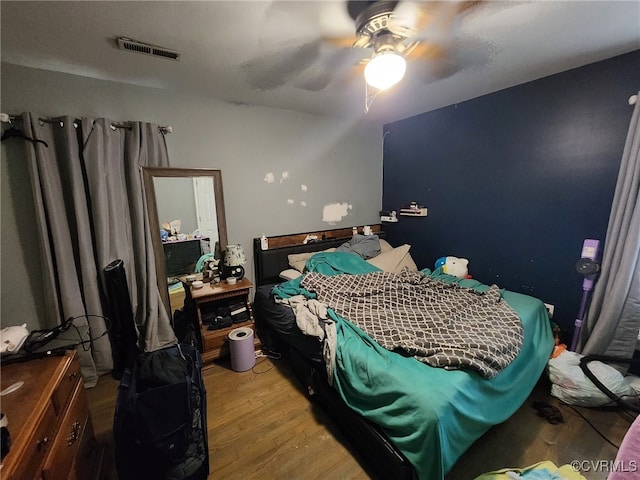 bedroom with visible vents, light wood-style floors, and ceiling fan