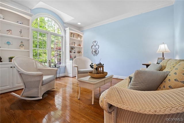 living area with baseboards, ornamental molding, and wood-type flooring