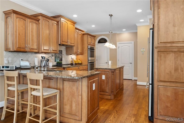 kitchen with backsplash, crown molding, baseboards, a peninsula, and dark stone counters