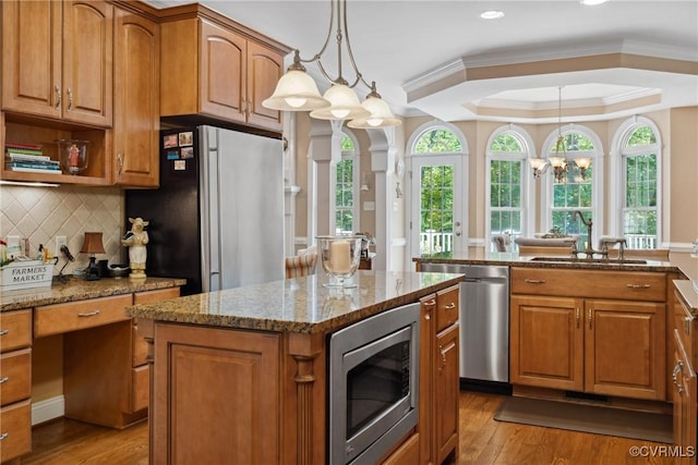 kitchen with a kitchen island, stainless steel appliances, and brown cabinets