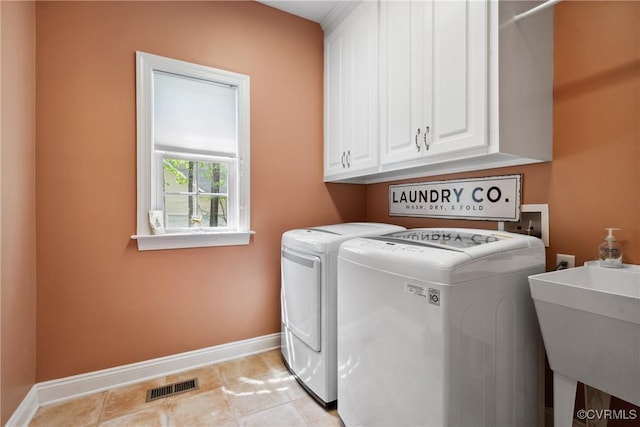 laundry room featuring visible vents, baseboards, separate washer and dryer, a sink, and cabinet space