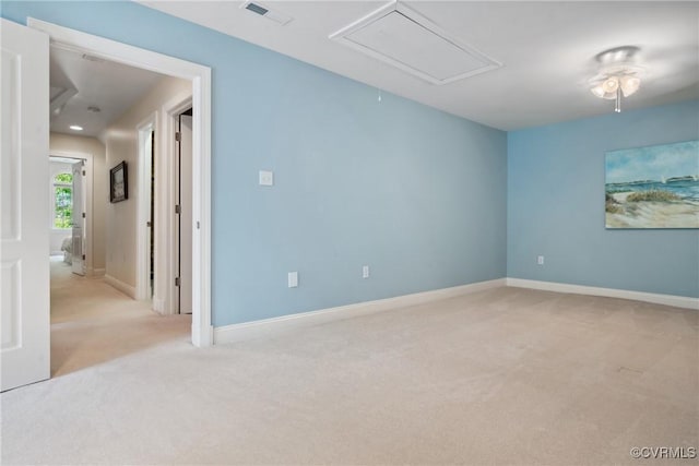 spare room with baseboards, carpet, attic access, and visible vents