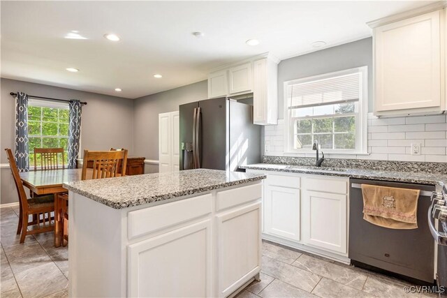 204 Pine St, Jarratt, VA 23867 - kitchen with a sink, appliances with stainless steel finishes, decorative backsplash, and light stone countertops