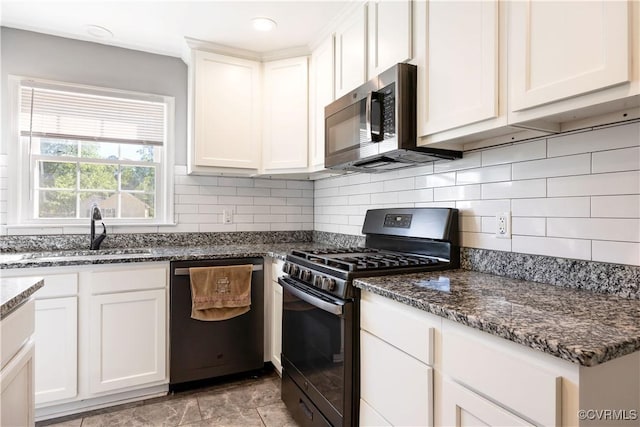 204 Pine St, Jarratt, VA 23867 - kitchen with backsplash, a sink, dark stone countertops, stainless steel appliances, and white cabinetry