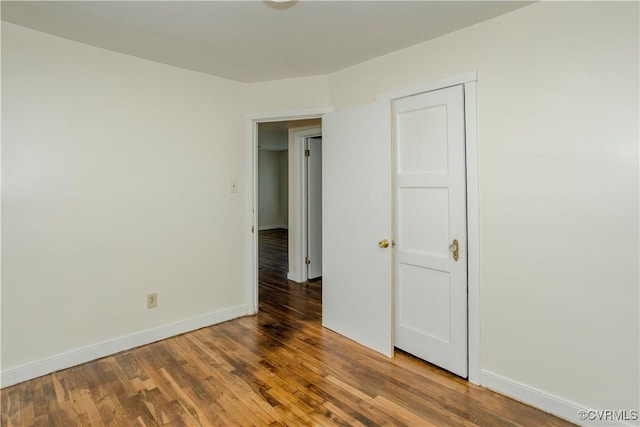 unfurnished room featuring baseboards and wood finished floors