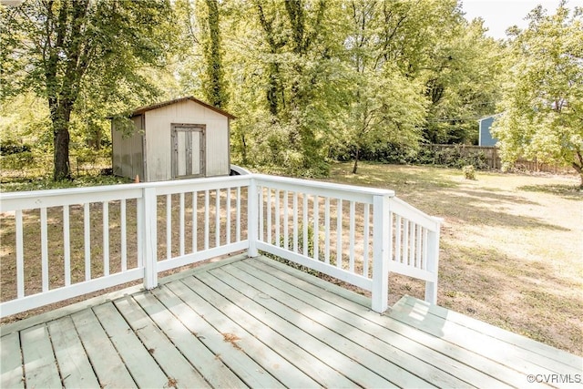 wooden deck with a shed, an outbuilding, and fence
