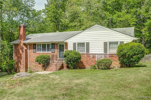 ranch-style house with a chimney, a front yard, roof with shingles, brick siding, and fence