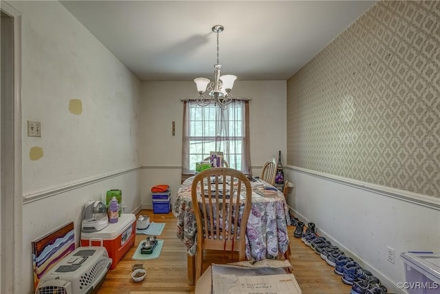 dining room with baseboards, wood finished floors, a chandelier, and wallpapered walls