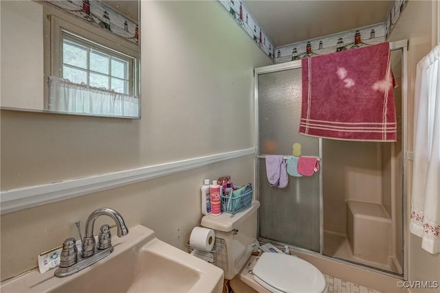full bathroom with toilet, a shower stall, and a sink