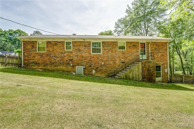 back of house with a yard, fence, and central AC unit