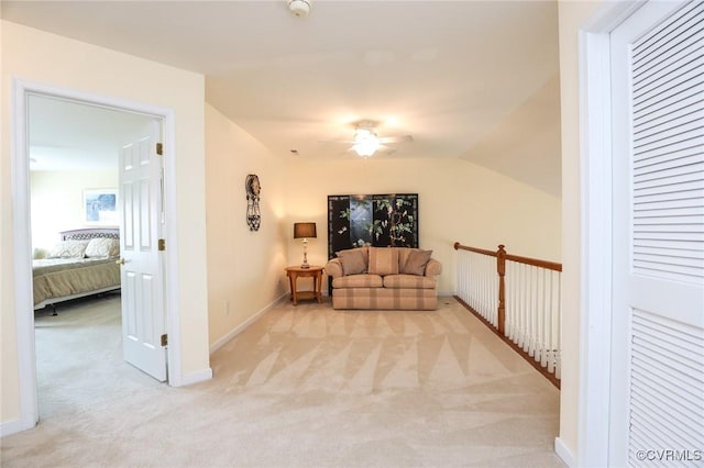 living room with baseboards, a ceiling fan, and light carpet