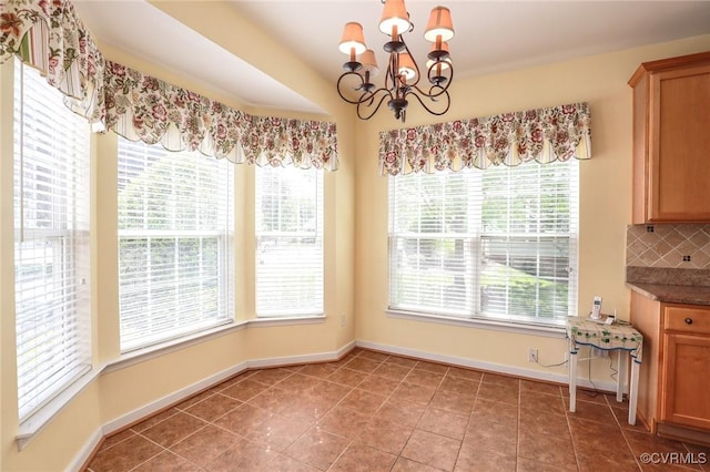 unfurnished dining area with baseboards, a notable chandelier, and light tile patterned floors