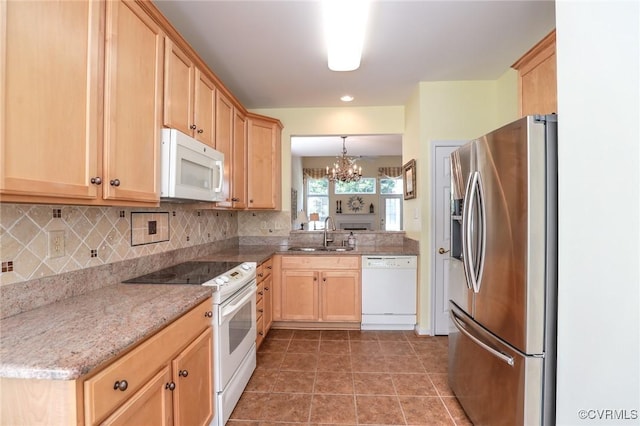 kitchen featuring a notable chandelier, a sink, light brown cabinets, white appliances, and backsplash