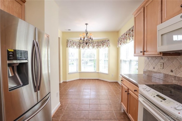 kitchen with decorative backsplash, tile patterned flooring, baseboards, a chandelier, and white appliances