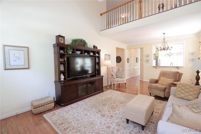 living room with baseboards, wood finished floors, and a chandelier