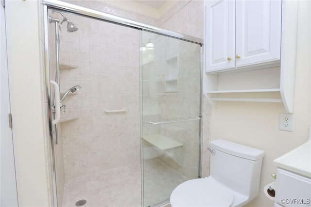 full bathroom with vanity, a stall shower, and toilet