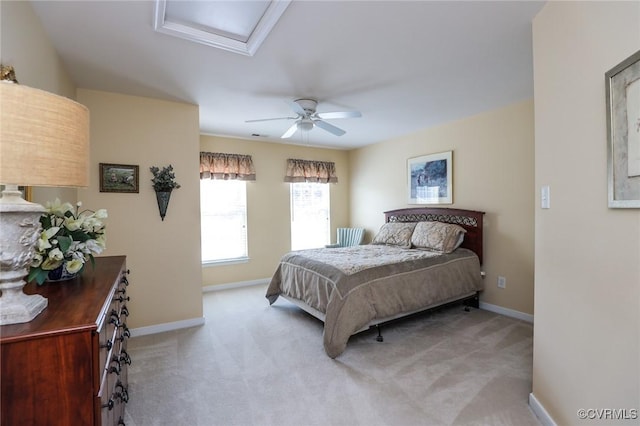 bedroom featuring a ceiling fan, baseboards, light carpet, and attic access