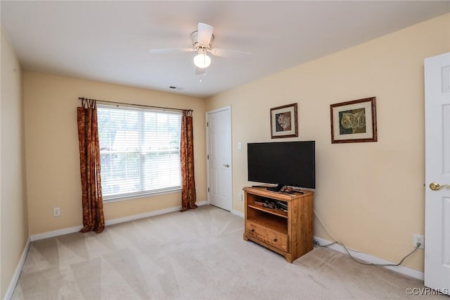 living area featuring baseboards, ceiling fan, visible vents, and light colored carpet