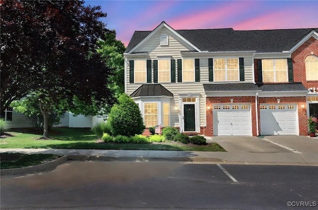 view of front of property with brick siding, an attached garage, and driveway