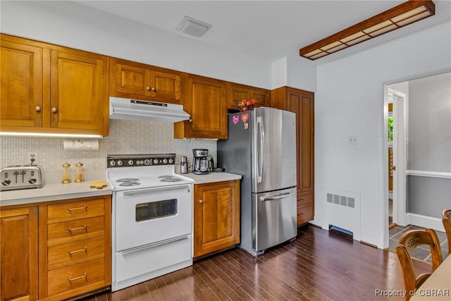 555 Rio Vis, Irvington, VA 22576 - kitchen featuring decorative backsplash, white range with electric stovetop, light countertops, freestanding refrigerator, and under cabinet range hood