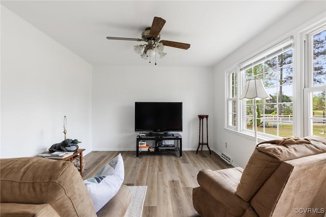 living room featuring visible vents, a ceiling fan, a healthy amount of sunlight, and light wood finished floors