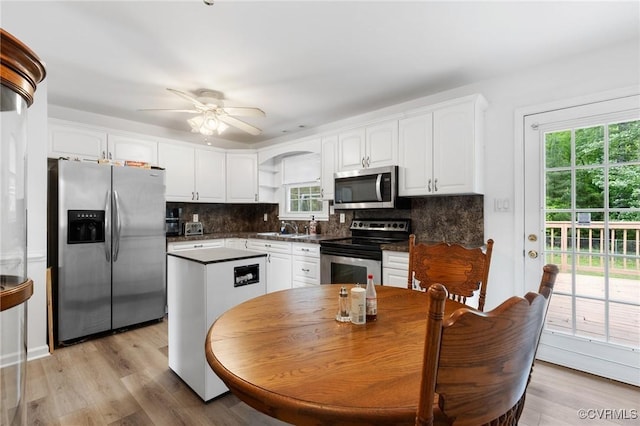 kitchen featuring appliances with stainless steel finishes, dark countertops, white cabinetry, and a sink