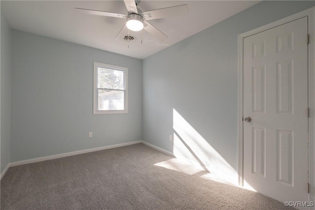 unfurnished room with a ceiling fan, visible vents, carpet, and baseboards