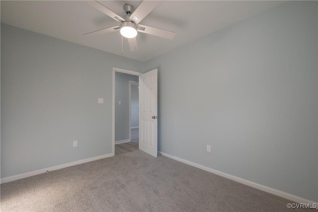 unfurnished room featuring a ceiling fan, baseboards, and light carpet
