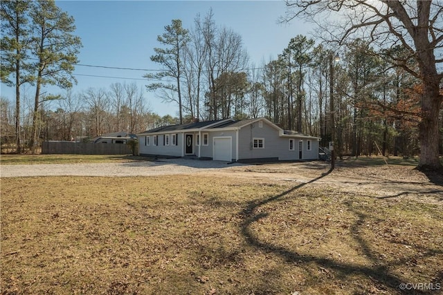 view of front of home with fence, a front lawn, and a garage