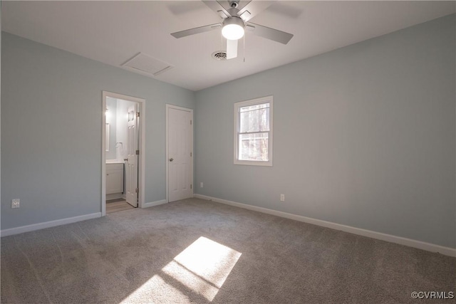 unfurnished bedroom with connected bathroom, ceiling fan, baseboards, attic access, and light carpet