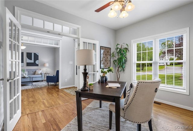 office area with french doors, a ceiling fan, light wood-style floors, and baseboards